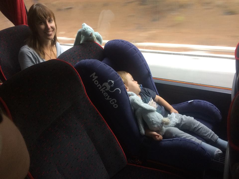 Jong kind in de MonkeyGo™ kinderstoel in slaap gevallen en de moeder is blij